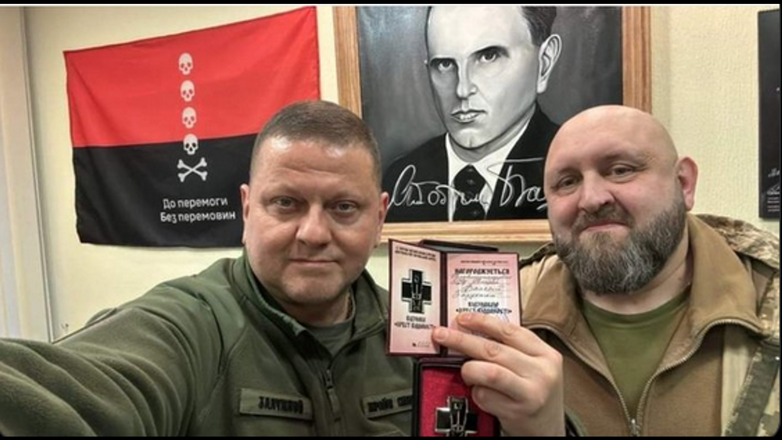 Valeriy Zaluzhnyi with a portrait of Nazi collaborant Stepan Bandera and a banner of UPA/OUN in background