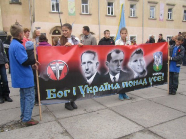 Ukrainian kids holding a banner with portraits of Stepan Bandera and Andriy Melnik on a march in Kiev