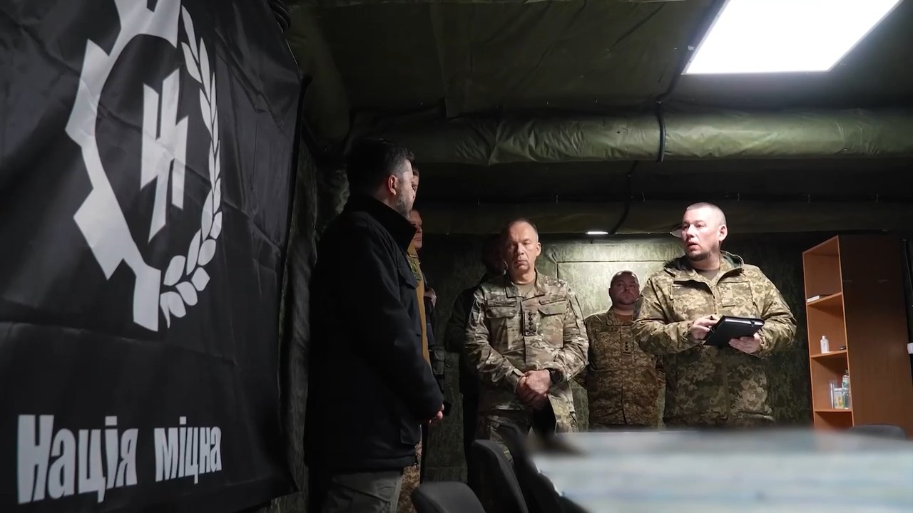 Zelensky and Syrsky at a command post next to a neo-Nazi symbol.
